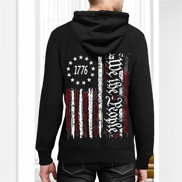 Back view of black hoodie featuring distressed vertical American flag with 13 stars and “1776,” alongside bold white vertical text reading “We the People”