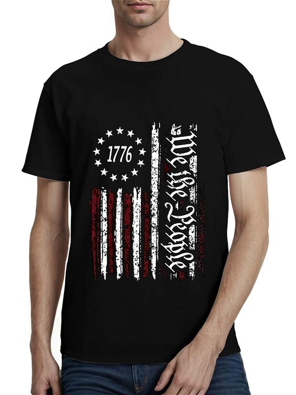 Black T-shirt featuring a distressed vertical American flag with red and white stripes, 13 stars around “1776,” and ornate vertical text reading “We the People”