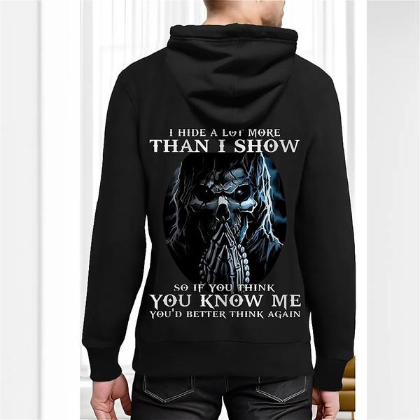 Back view of black hoodie featuring a mysterious figure with long hair and sunglasses, surrounded by blue aura, with bold white text reading “I hide a lot more than I show…